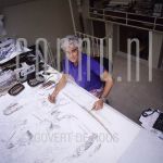 Corstiaan de Vries (Date Unknown) at atelier in Amsterdam.

[keywords]Posed, Half Length, Eyecontact, Smiling, Drawing table[/keywords]